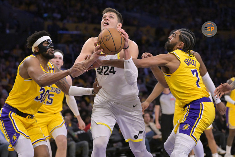 Feb 10, 2025; Los Angeles, California, USA; Los Angeles Lakers guard Jordan Goodwin (30) and guard Jordan Goodwin (7) defend Utah Jazz center Walker Kessler (24) in the second half at Crypto.com Arena. Credit: Jayne Kamin-Oncea-Imagn Images