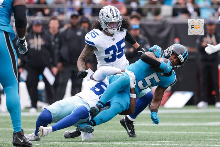 Oct 12, 2025; Charlotte, North Carolina, USA; Dallas Cowboys linebacker Shemar James (50) tackles Carolina Panthers running back Rico Dowdle (5) during the second half at Bank of America Stadium. Credit: Scott Kinser-Imagn Images