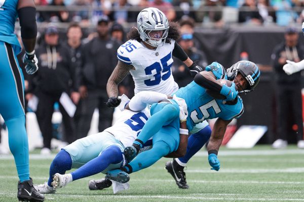 Oct 12, 2025; Charlotte, North Carolina, USA; Dallas Cowboys linebacker Shemar James (50) tackles Carolina Panthers running back Rico Dowdle (5) during the second half at Bank of America Stadium. Mandatory Credit: Scott Kinser-Imagn Images
