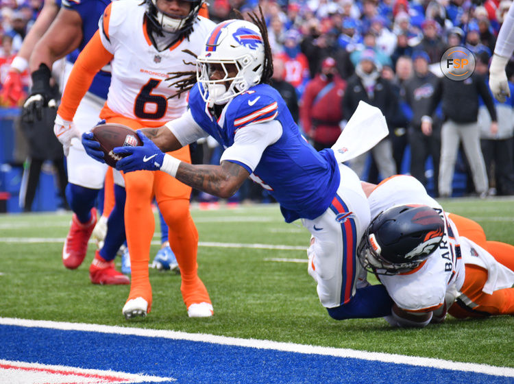 Jan 12, 2025; Orchard Park, New York, USA; Buffalo Bills running back James Cook (4) dives for a touchdown as Denver Broncos linebacker Cody Barton (55) tackles during the second quarter in an AFC wild card game at Highmark Stadium. Credit: Mark Konezny-Imagn Images