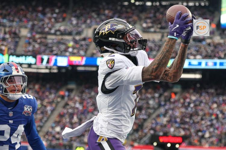 Dec 15, 2024; East Rutherford, New Jersey, USA; Baltimore Ravens wide receiver Rashod Bateman (7) catches a touchdown pass in front of New York Giants safety Dane Belton (24) during the first half at MetLife Stadium. Credit: Vincent Carchietta-Imagn Images