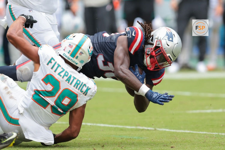 Sep 14, 2025; Miami Gardens, Florida, USA; New England Patriots running back Rhamondre Stevenson (38) carries the football against Miami Dolphins safety Minkah Fitzpatrick (29) during the fourth quarter at Hard Rock Stadium. Credit: Sam Navarro-Imagn Images