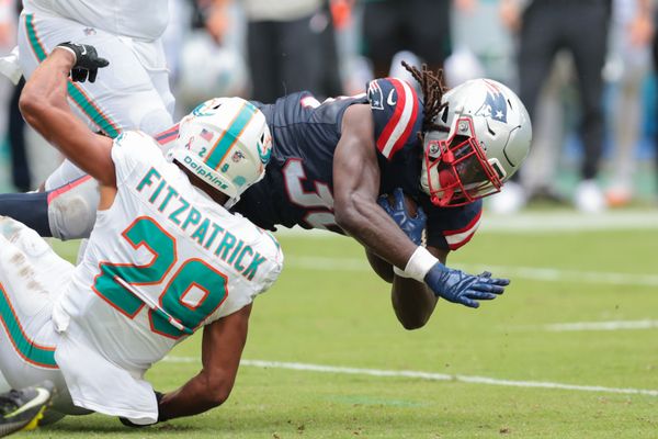 Sep 14, 2025; Miami Gardens, Florida, USA; New England Patriots running back Rhamondre Stevenson (38) carries the football against Miami Dolphins safety Minkah Fitzpatrick (29) during the fourth quarter at Hard Rock Stadium. Mandatory Credit: Sam Navarro-Imagn Images