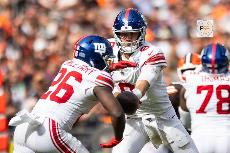 Sep 22, 2024; Cleveland, Ohio, USA; New York Giants quarterback Daniel Jones (8) hands the ball off to running back Devin Singletary (26) during the fourth quarter against the Cleveland Browns at Huntington Bank Field. Credit: Scott Galvin-Imagn Images