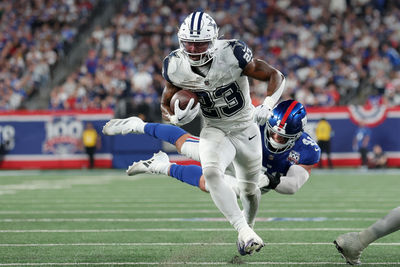 Sep 26, 2024; East Rutherford, New Jersey, USA; Dallas Cowboys running back Rico Dowdle (23) runs for a touchdown against New York Giants linebacker Micah McFadden (41) during the first quarter at MetLife Stadium. Mandatory Credit: Brad Penner-Imagn Images