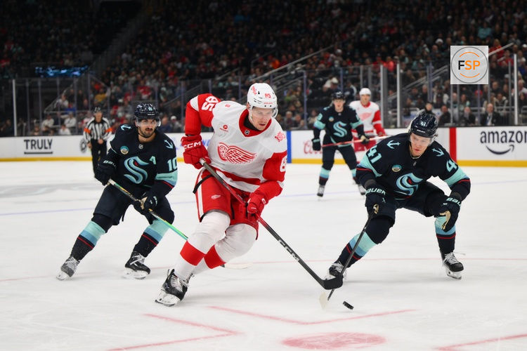 Dec 6, 2025; Seattle, Washington, USA; Detroit Red Wings left wing Elmer Soderblom (85) advances the puck while defended by Seattle Kraken defenseman Ryker Evans (41) during the third period at Climate Pledge Arena. Credit: Steven Bisig-Imagn Images