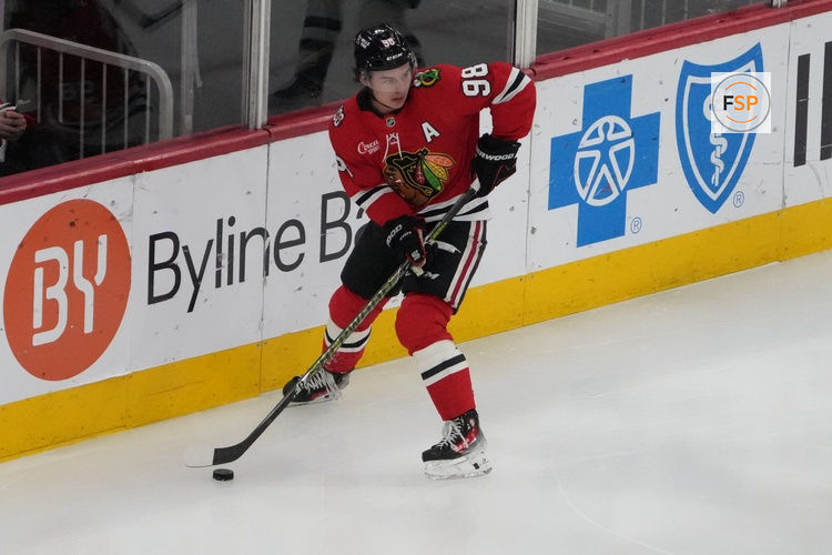 Apr 15, 2026; Chicago, Illinois, USA; Chicago Blackhawks center Connor Bedard (98) grabs the puck against the San Jose Sharks during the first period at United Center. Credit: David Banks-Imagn Images
