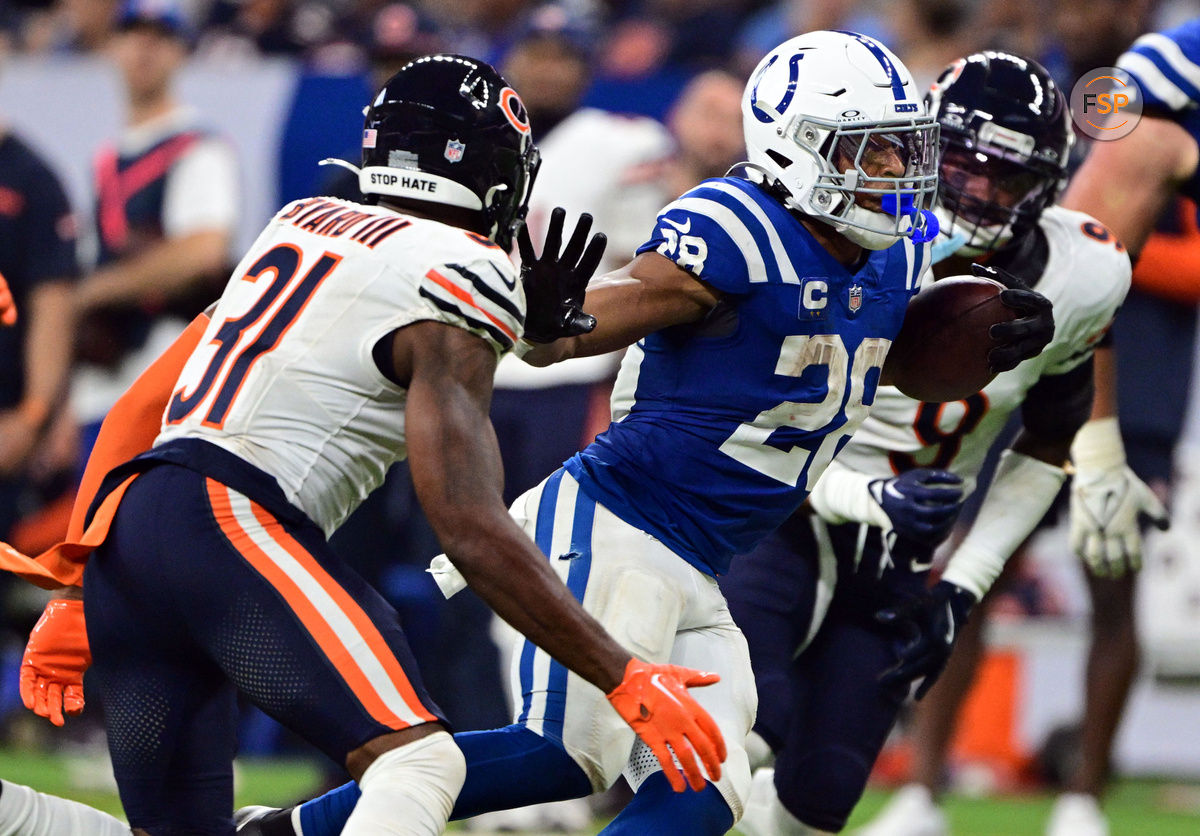 Sep 22, 2024; Indianapolis, Indiana, USA; Indianapolis Colts running back Jonathan Taylor (28) holds his arm out to block coverage from Chicago Bears safety Kevin Byard III (31) during the second half at Lucas Oil Stadium. Credit: Marc Lebryk-Imagn Images

