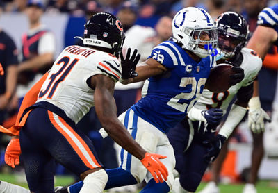 Sep 22, 2024; Indianapolis, Indiana, USA; Indianapolis Colts running back Jonathan Taylor (28) holds his arm out to block coverage from Chicago Bears safety Kevin Byard III (31) during the second half at Lucas Oil Stadium. Mandatory Credit: Marc Lebryk-Imagn Images

