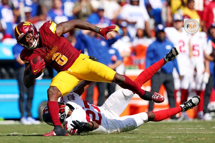 Sep 15, 2024; Landover, Maryland, USA; Washington Commanders running back Brian Robinson Jr. (8) runs the ball against New York Giants safety Jason Pinnock (27) during the third quarter at Commanders Field. Credit: Peter Casey-Imagn Images