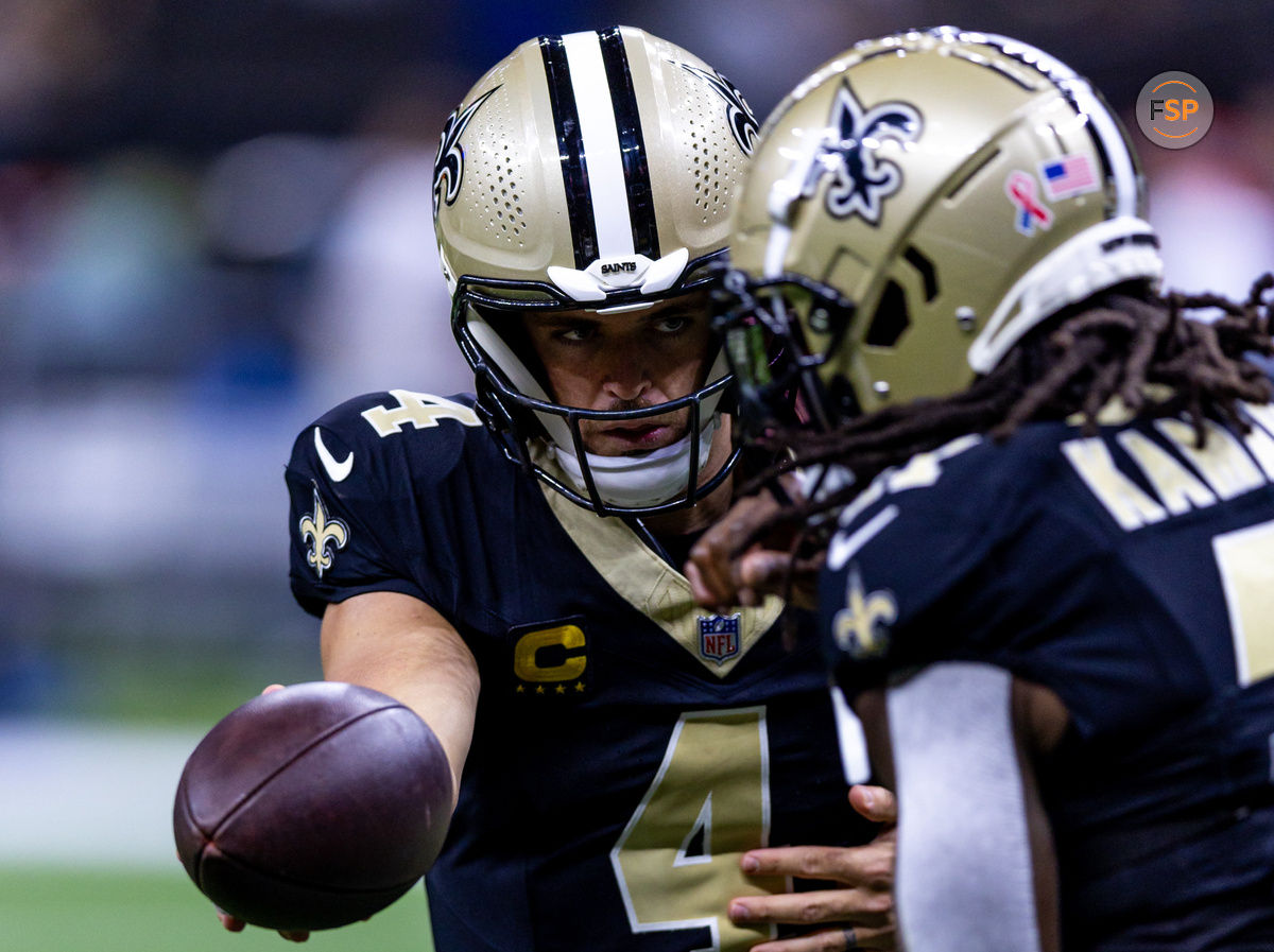 Sep 8, 2024; New Orleans, Louisiana, USA;  New Orleans Saints quarterback Derek Carr (4) hands off to running back Alvin Kamara (41) against the Carolina Panthers during the pregame at Caesars Superdome. Credit: Stephen Lew-Imagn Images