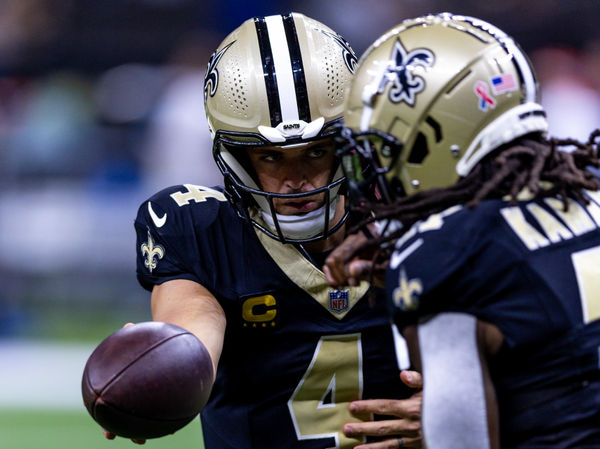 Sep 8, 2024; New Orleans, Louisiana, USA;  New Orleans Saints quarterback Derek Carr (4) hands off to running back Alvin Kamara (41) against the Carolina Panthers during the pregame at Caesars Superdome. Mandatory Credit: Stephen Lew-Imagn Images