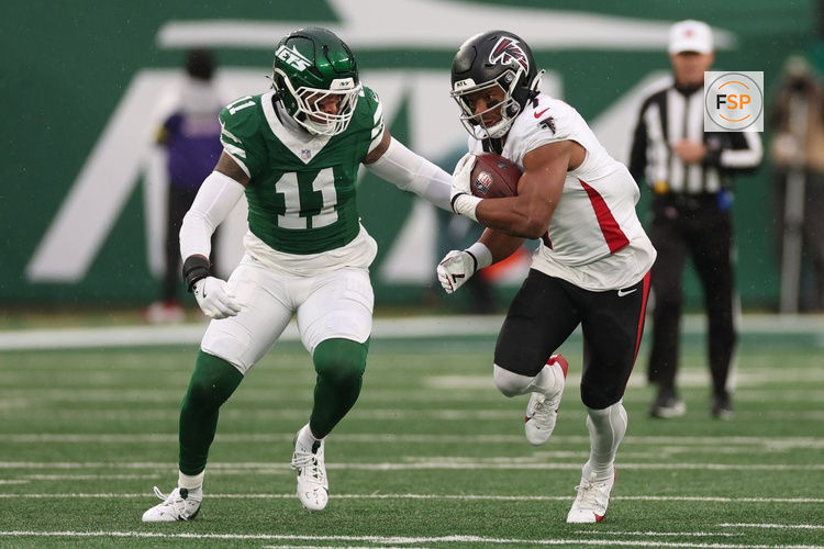 Nov 30, 2025; East Rutherford, New Jersey, USA; Atlanta Falcons running back Bijan Robinson (7) rushes the ball past New York Jets linebacker Jermaine Johnson (11)  during the first half at MetLife Stadium. Credit: Vincent Carchietta-Imagn Images