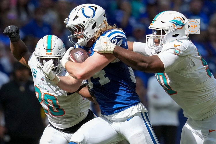Miami Dolphins linebacker Jordyn Brooks (20) and defensive tackle Kenneth Grant (90) work to bring down Indianapolis Colts tight end Tyler Warren (84) during the second half of a game Sunday, Sept. 7, 2025, at Lucas Oil Stadium in Indianapolis. The Colts defeated the Dolphins 33-8.