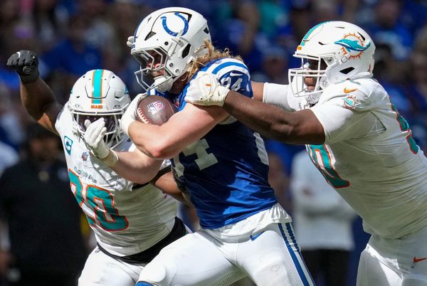Miami Dolphins linebacker Jordyn Brooks (20) and defensive tackle Kenneth Grant (90) work to bring down Indianapolis Colts tight end Tyler Warren (84) during the second half of a game Sunday, Sept. 7, 2025, at Lucas Oil Stadium in Indianapolis. The Colts defeated the Dolphins 33-8.