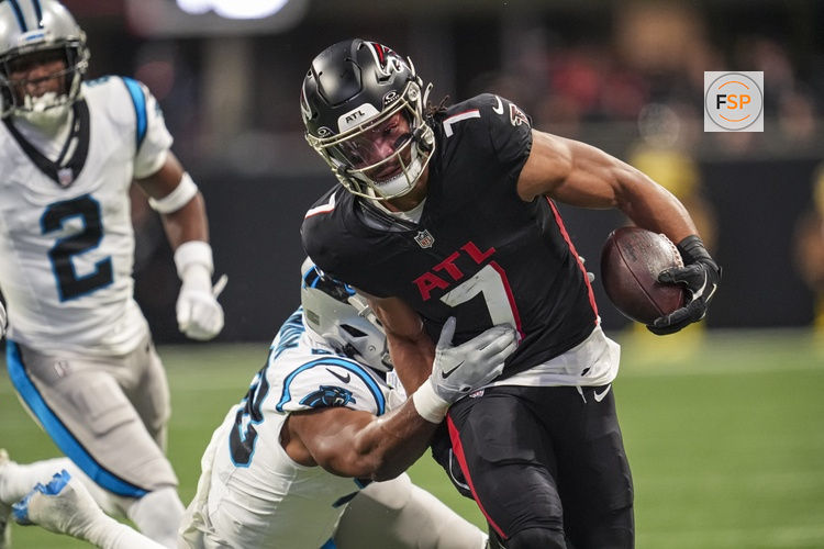 Jan 5, 2025; Atlanta, Georgia, USA; Atlanta Falcons running back Bijan Robinson (7) runs against Carolina Panthers linebacker D.J. Wonnum (98) during the first quarter at Mercedes-Benz Stadium. Credit: Dale Zanine-Imagn Images