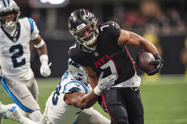 Jan 5, 2025; Atlanta, Georgia, USA; Atlanta Falcons running back Bijan Robinson (7) runs against Carolina Panthers linebacker D.J. Wonnum (98) during the first quarter at Mercedes-Benz Stadium. Mandatory Credit: Dale Zanine-Imagn Images