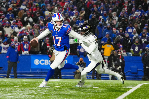 Jan 19, 2025; Orchard Park, New York, USA; Buffalo Bills quarterback Josh Allen (17) avoids a tackle from Baltimore Ravens cornerback Nate Wiggins (2) during the third quarter in a 2025 AFC divisional round game at Highmark Stadium. Mandatory Credit: Gregory Fisher-Imagn Images