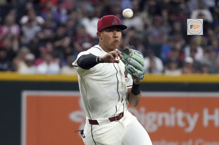 Mar 31, 2026; Phoenix, Arizona, USA; Arizona Diamondbacks third baseman Jose Fernandez (11) makes the off balance throw for an out against the Detroit Tigers in the first inning at Chase Field. Credit: Rick Scuteri-Imagn Images