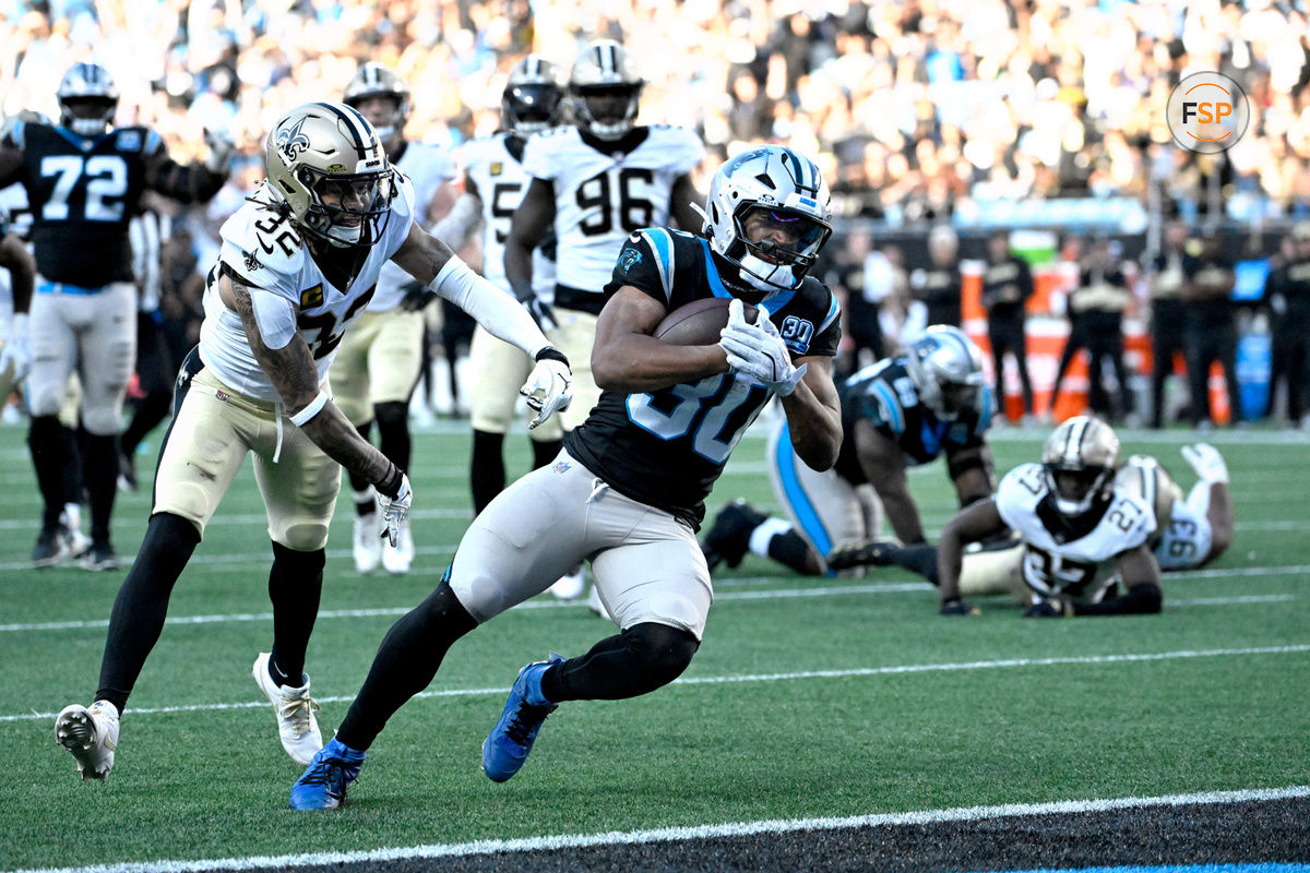 Nov 3, 2024; Charlotte, North Carolina, USA; Carolina Panthers running back Chuba Hubbard (30) scores the winning touchdown as New Orleans Saints safety Tyrann Mathieu (32) defends in the fourth qarter at Bank of America Stadium. Credit: Bob Donnan-Imagn Images