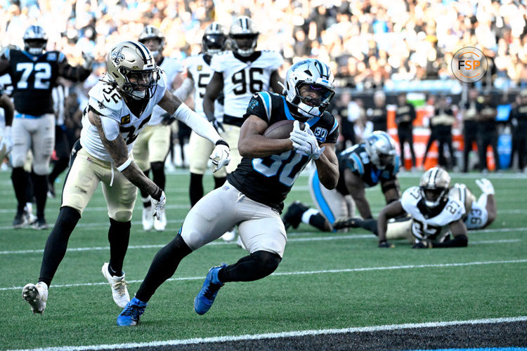 Nov 3, 2024; Charlotte, North Carolina, USA; Carolina Panthers running back Chuba Hubbard (30) scores the winning touchdown as New Orleans Saints safety Tyrann Mathieu (32) defends in the fourth qarter at Bank of America Stadium. Credit: Bob Donnan-Imagn Images