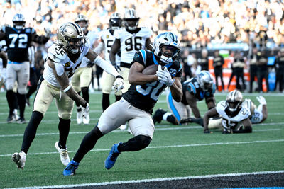 Nov 3, 2024; Charlotte, North Carolina, USA; Carolina Panthers running back Chuba Hubbard (30) scores the winning touchdown as New Orleans Saints safety Tyrann Mathieu (32) defends in the fourth qarter at Bank of America Stadium. Mandatory Credit: Bob Donnan-Imagn Images