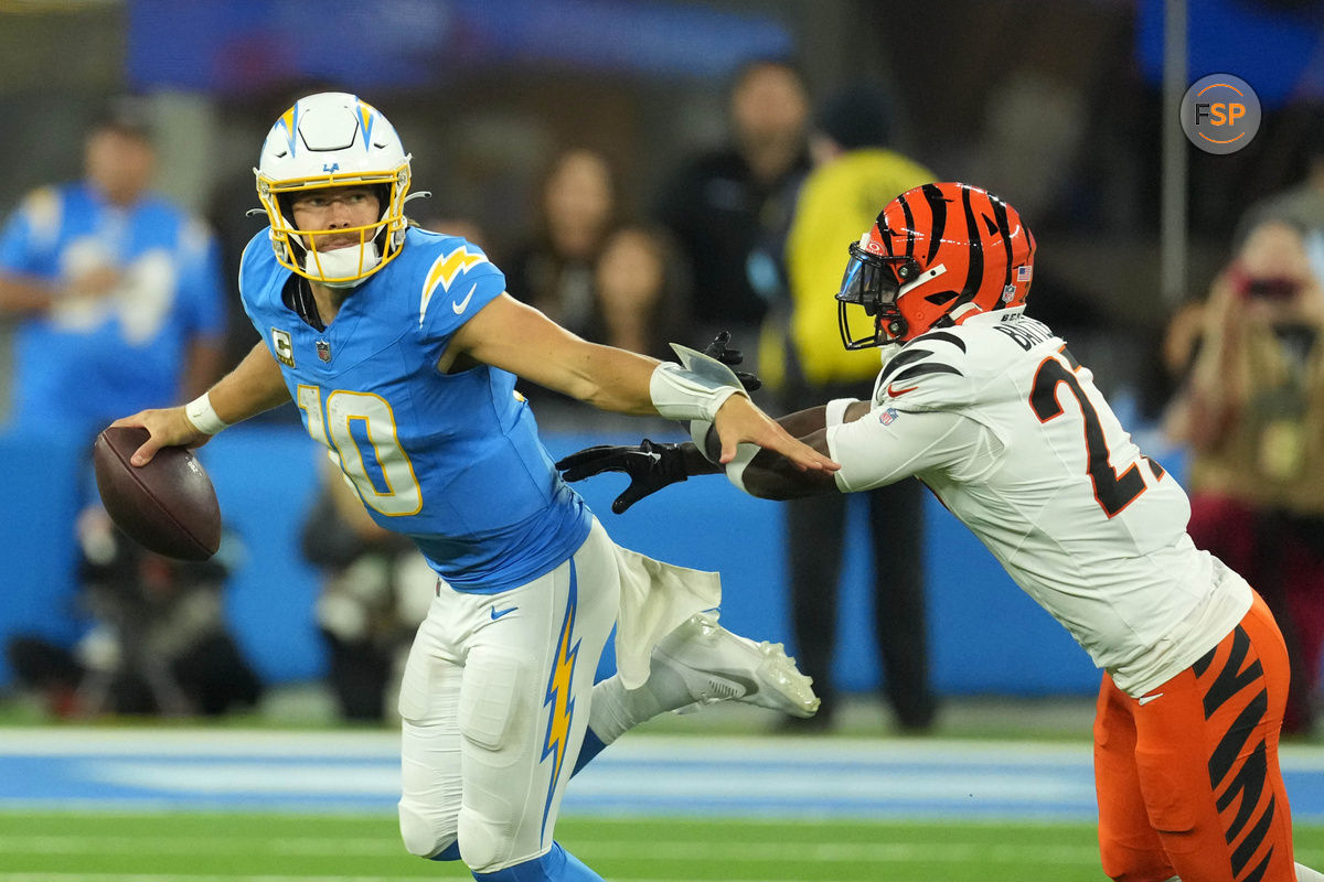 Nov 17, 2024; Inglewood, California, USA; Los Angeles Chargers quarterback Justin Herbert (10) is pressured by Cincinnati Bengals cornerback Josh Newton (28) in the second half at SoFi Stadium. Credit: Kirby Lee-Imagn Images