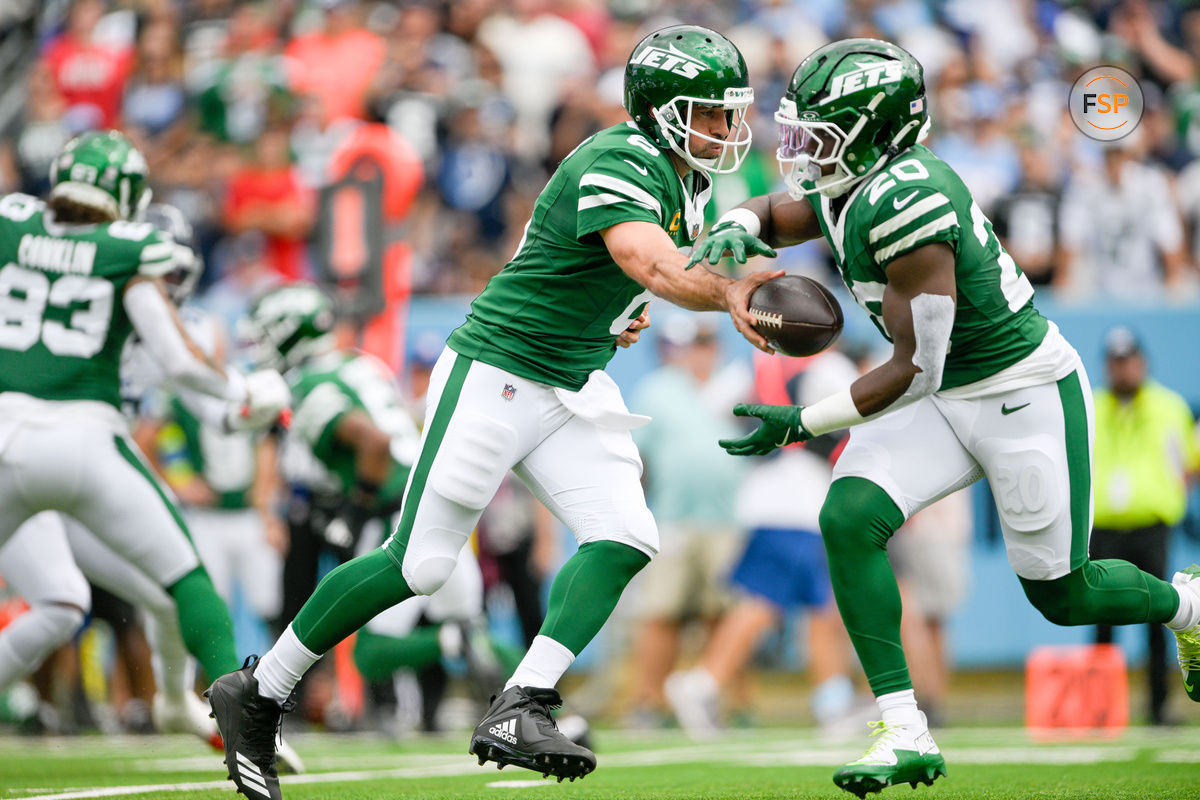 Sep 15, 2024; Nashville, Tennessee, USA;  New York Jets quarterback Aaron Rodgers (8) hands the ball to running back Breece Hall (20) against the Tennessee Titans during the first half at Nissan Stadium. Credit: Steve Roberts-Imagn Images