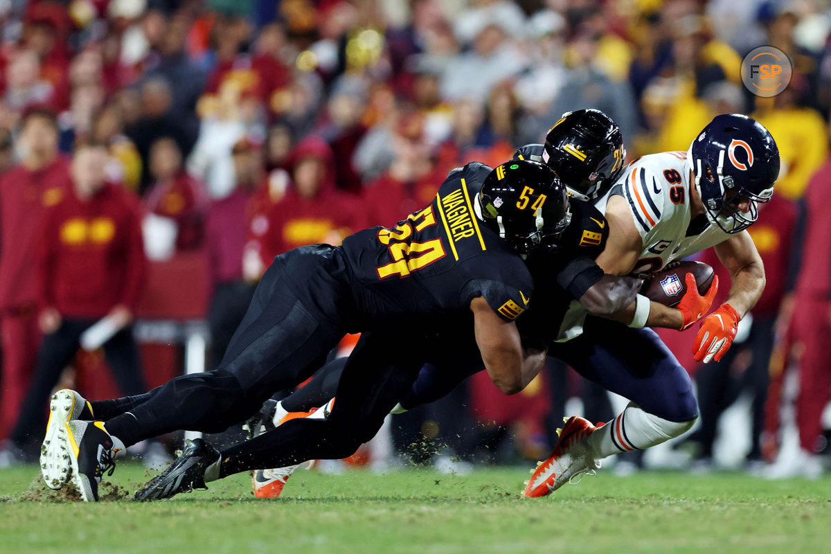 Oct 27, 2024; Landover, Maryland, USA; Chicago Bears tight end Cole Kmet (85) catches a pass against Washington Commanders linebacker Bobby Wagner (54) during the fourth quarter at Commanders Field. Credit: Peter Casey-Imagn Images