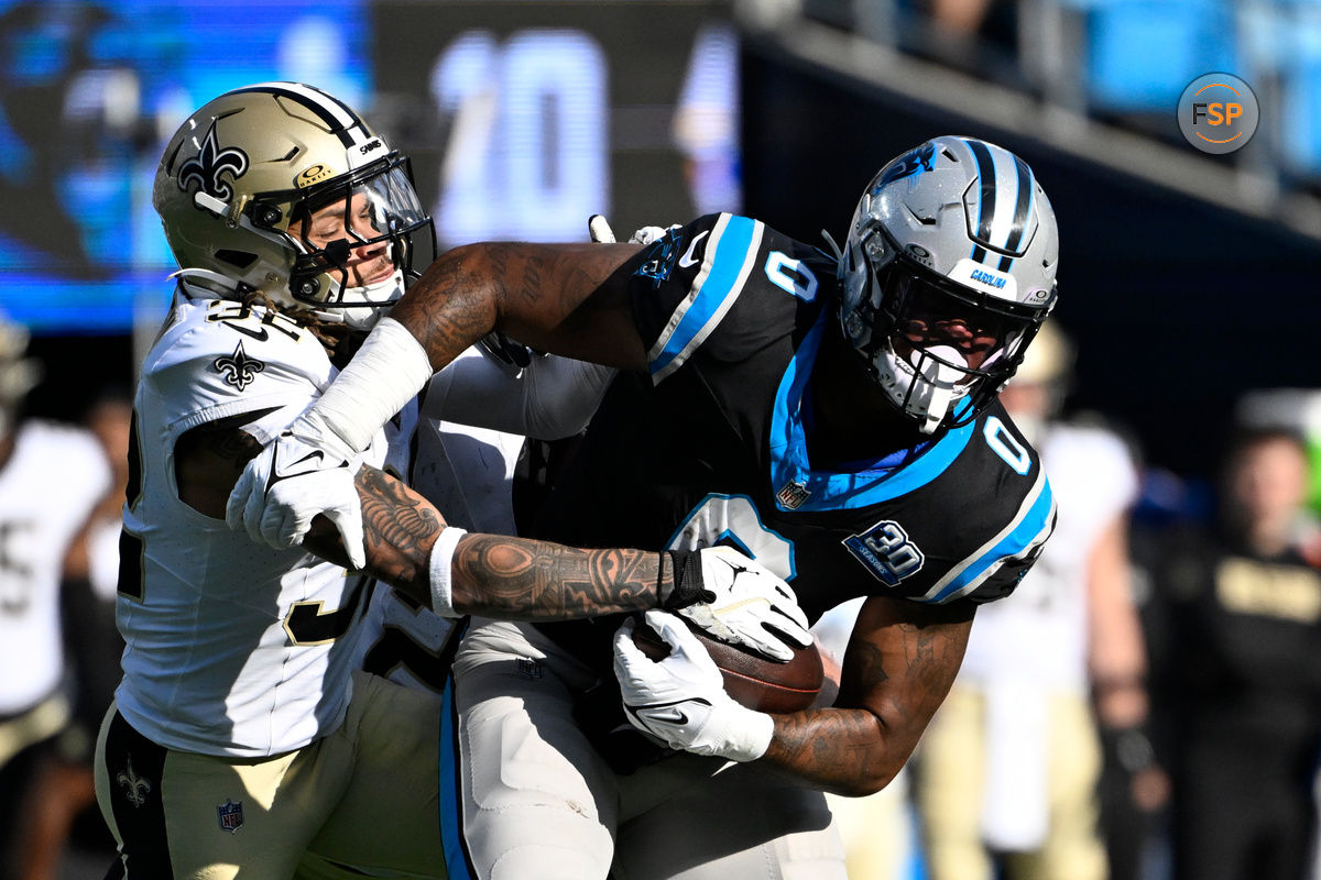 Nov 3, 2024; Charlotte, North Carolina, USA; Carolina Panthers tight end Ja'Tavion Sanders (0) with the ball as New Orleans Saints safety Tyrann Mathieu (32) defends in the third quarter at Bank of America Stadium. Credit: Bob Donnan-Imagn Images