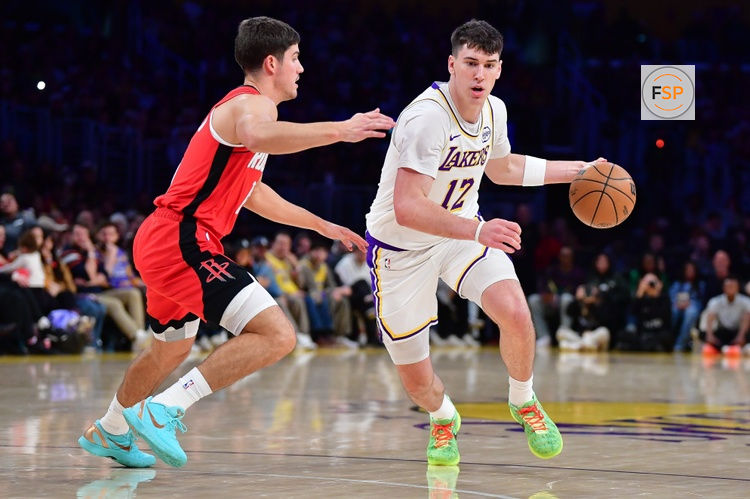 Dec 25, 2025; Los Angeles, California, USA; Los Angeles Lakers forward Jake LaRavia (12) moves to the basket against Houston Rockets guard Reed Sheppard (15) during the first half at Crypto.com Arena. Credit: Gary A. Vasquez-Imagn Images