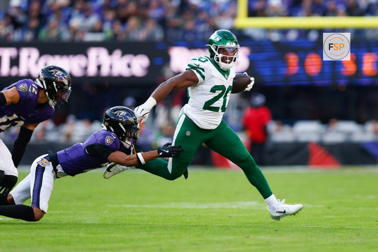 Nov 23, 2025; Baltimore, Maryland, USA;  New York Jets running back Breece Hall (20) rushes as Baltimore Ravens cornerback Nate Wiggins (2) defends during the fourth quarter at M&T Bank Stadium. Credit: Peter Casey-Imagn Images