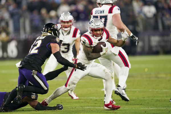 Dec 21, 2025; Baltimore, Maryland, USA;  New England Patriots running back Treveyon Henderson (32) runs the ball against Baltimore Ravens safety Alohi Gilman (12) during the first half of the game at M&T Bank Stadium. Mandatory Credit: Mitch Stringer-Imagn Images
