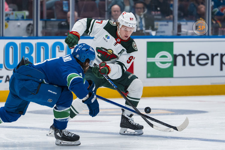 Apr 12, 2025; Vancouver, British Columbia, CAN; Vancouver Canucks forward Conor Garland (8) checks Minnesota Wild forward Kirill Kaprizov (97) in the first period at Rogers Arena. Credit: Bob Frid-Imagn Images