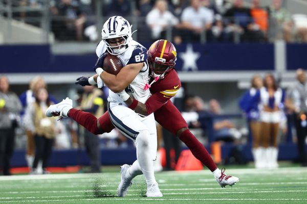 Oct 19, 2025; Arlington, Texas, USA; Dallas Cowboys tight end Jake Ferguson (87) carries the ball defended by Washington Commanders safety Quan Martin (20) during the second quarter of the game at AT&T Stadium. Mandatory Credit: Kevin Jairaj-Imagn Images