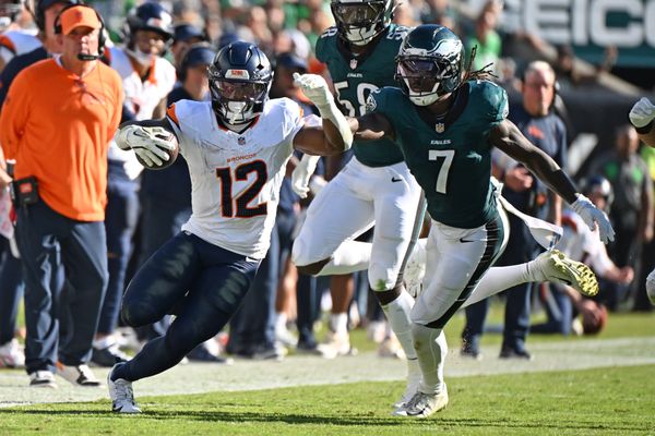 Oct 5, 2025; Philadelphia, Pennsylvania, USA; Denver Broncos running back RJ Harvey (12) runs past Philadelphia Eagles cornerback Kelee Ringo (7) at Lincoln Financial Field. Mandatory Credit: Eric Hartline-Imagn Images
