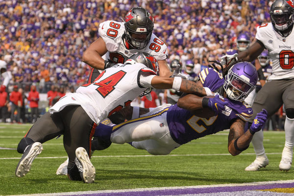 MINNEAPOLIS, MN - SEPTEMBER 10: Minnesota Vikings running back Alexander Mattison (2) dives into the end zone for a 4-yard touchdown reception as Tampa Bay Buccaneers defensive back Carlton Davis (24) and Tampa Bay Buccaneers defensive lineman Logan Hall (90) close in during the fourth quarter of an NFL game between the Minnesota Vikings and Tampa Bay Buccaneers  on September 10, 2023, at U.S. Bank Stadium in Minneapolis, MN. (Photo by Nick Wosika/Icon Sportswire)