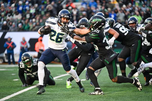 Dec 1, 2024; East Rutherford, New Jersey, USA; Seattle Seahawks running back Zach Charbonnet (26) stiff arms New York Jets safety Jalen Mills (35) during the third quarter at MetLife Stadium. Mandatory Credit: Mark Smith-Imagn Images