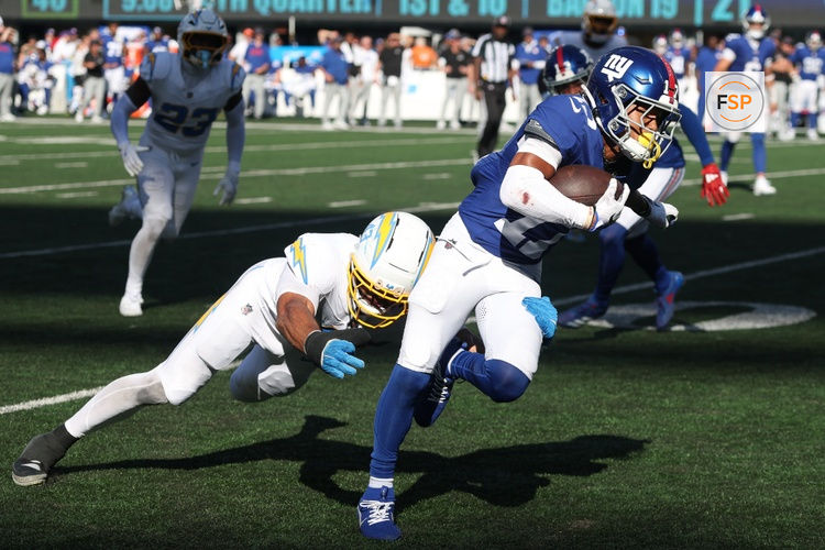 Sep 28, 2025; East Rutherford, New Jersey, USA; New York Giants wide receiver Wan'Dale Robinson (17) gains yards after catch as Los Angeles Chargers linebacker Troy Dye (43) tackles during the second half at MetLife Stadium. Credit: Vincent Carchietta-Imagn Images