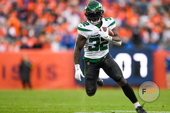 DENVER, COLORADO - OCTOBER 23: Michael Carter #32 of the New York Jets runs with the ball for a first down against the Denver Broncos during the third quarter at Empower Field At Mile High on October 23, 2022 in Denver, Colorado. (Photo by Dustin Bradford/Getty Images)
