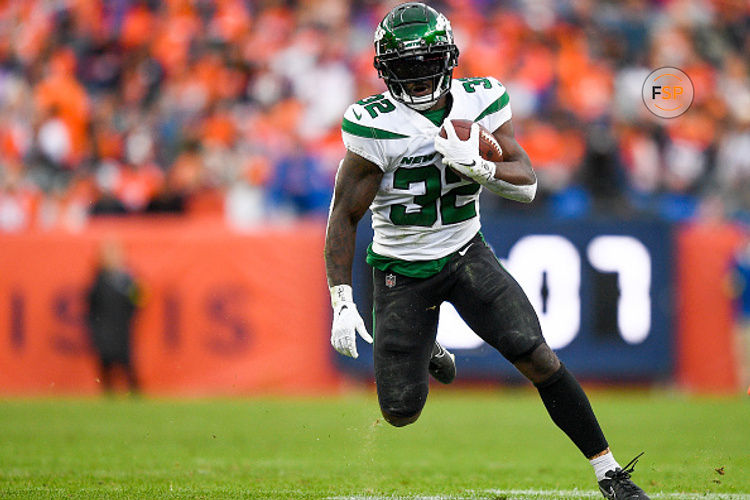 DENVER, COLORADO - OCTOBER 23: Michael Carter #32 of the New York Jets runs with the ball for a first down against the Denver Broncos during the third quarter at Empower Field At Mile High on October 23, 2022 in Denver, Colorado. (Photo by Dustin Bradford/Getty Images)