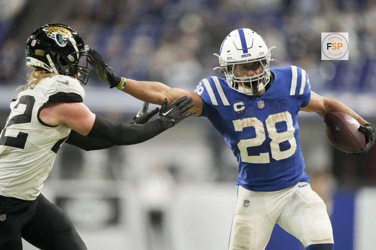 Jan 5, 2025; Indianapolis, Indiana, USA; Indianapolis Colts running back Jonathan Taylor (28) pushes off Jacksonville Jaguars cornerback De'Antre Prince (24) as he rushes the ball during a game against the Jacksonville Jaguar at Lucas Oil Stadium. Credit: Grace Hollars/USA TODAY Network via Imagn Images