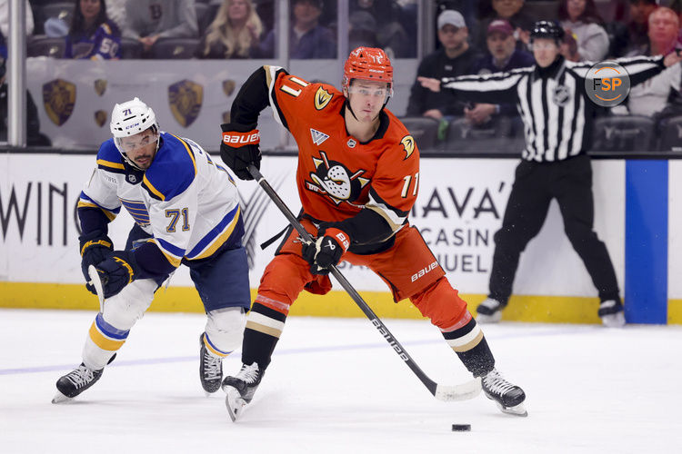 Mar 7, 2025; Anaheim, California, USA; Anaheim Ducks center Trevor Zegras (11) moves the puck ahead of St. Louis Blues right wing Mathieu Joseph (71) during the second period at Honda Center. Credit: Ryan Sun-Imagn Images