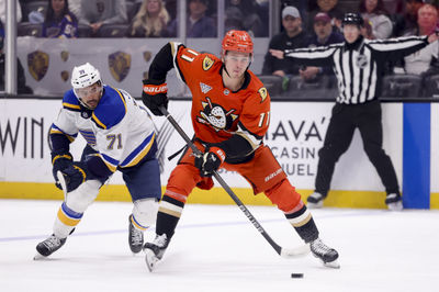 Mar 7, 2025; Anaheim, California, USA; Anaheim Ducks center Trevor Zegras (11) moves the puck ahead of St. Louis Blues right wing Mathieu Joseph (71) during the second period at Honda Center. Mandatory Credit: Ryan Sun-Imagn Images