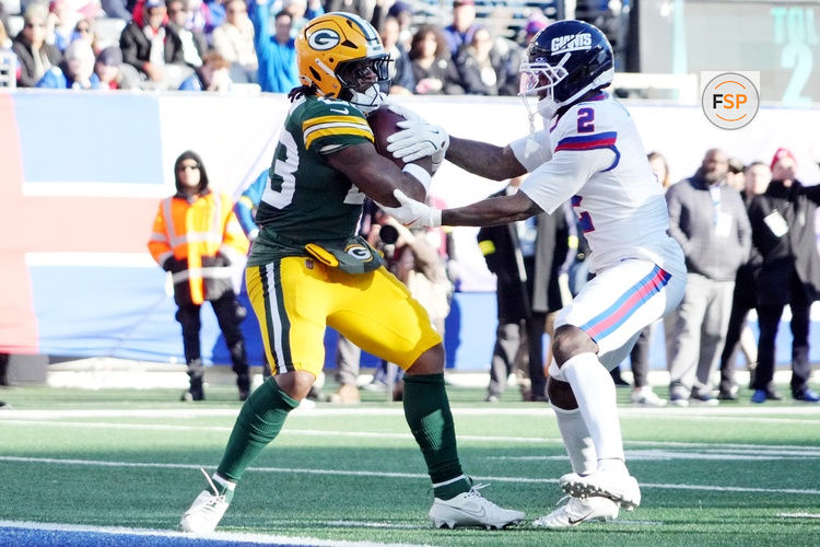 Nov 16, 2025; East Rutherford, New Jersey, USA; Green Bay Packers running back Emanuel Wilson (23) scores a touchdown against New York Giants cornerback Deonte Banks (2) during the second quarter at MetLife Stadium. Credit: Robert Deutsch-Imagn Images