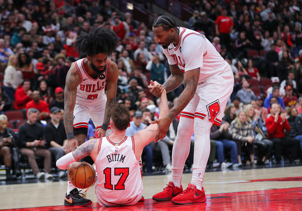 CHICAGO, IL - FEBRUARY 28: Coby White #0 of the Chicago Bulls and Andre Drummond #3 of the Chicago Bulls help Onuralp Bitim #17 of the Chicago Bulls up after a foul during overtime against the Cleveland Cavaliers at the United Center on February 28, 2024 in Chicago, Illinois. (Photo by Melissa Tamez/Icon Sportswire)