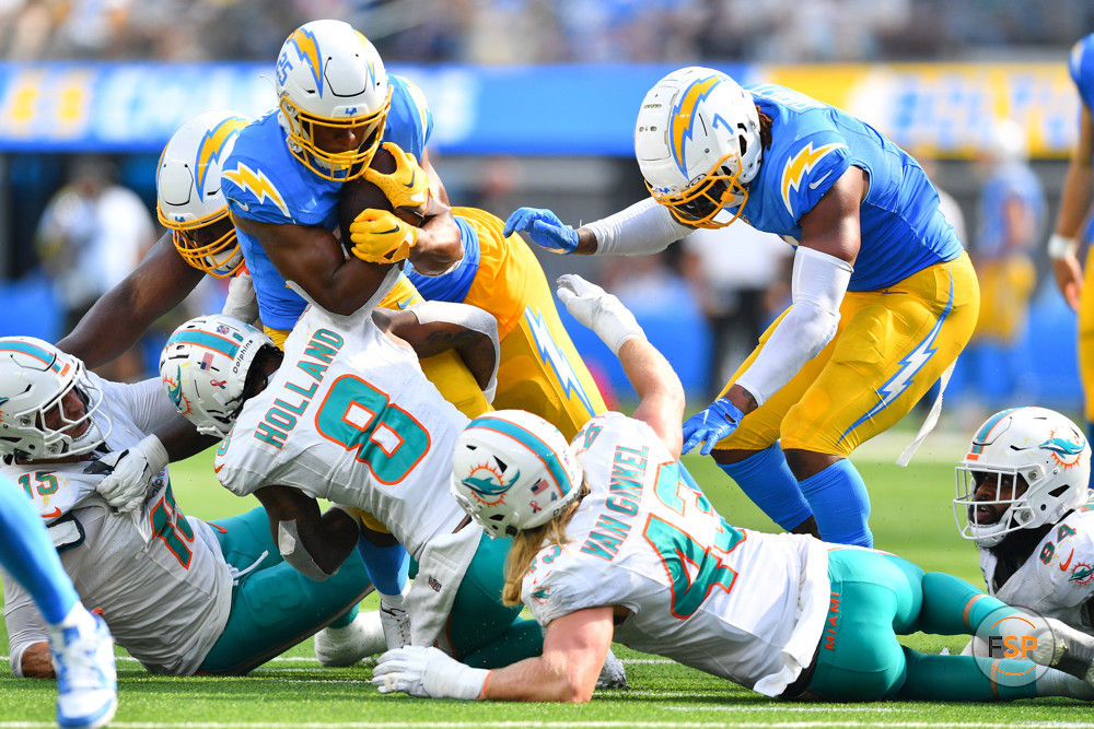 INGLEWOOD, CA - SEPTEMBER 10: Los Angeles Chargers running back Joshua Kelley (25) is tackled by Miami Dolphins safety Jevon Holland (8) during the NFL regular season game between the Miami Dolphins and the Los Angeles Chargers on September 10, 2023, at SoFi Stadium in Inglewood, CA. (Photo by Brian Rothmuller/Icon Sportswire)