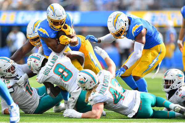 INGLEWOOD, CA - SEPTEMBER 10: Los Angeles Chargers running back Joshua Kelley (25) is tackled by Miami Dolphins safety Jevon Holland (8) during the NFL regular season game between the Miami Dolphins and the Los Angeles Chargers on September 10, 2023, at SoFi Stadium in Inglewood, CA. (Photo by Brian Rothmuller/Icon Sportswire)