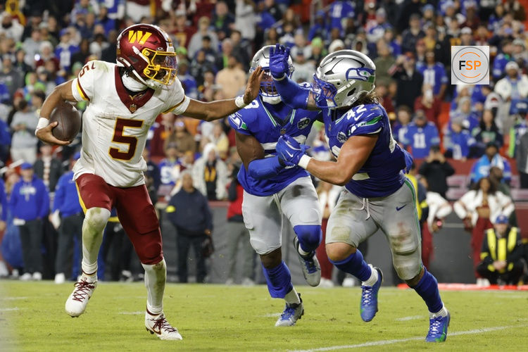 Nov 2, 2025; Landover, Maryland, USA; Washington Commanders quarterback Jayden Daniels (5) runs the ball defended by Seattle Seahawks linebacker Drake Thomas (42) during the second half at Northwest Stadium. Credit: Amber Searls-Imagn Images