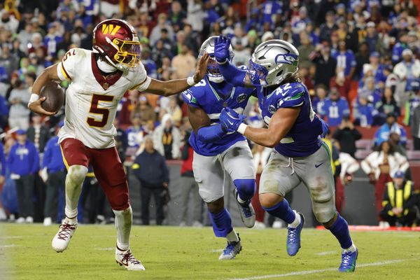 Nov 2, 2025; Landover, Maryland, USA; Washington Commanders quarterback Jayden Daniels (5) runs the ball defended by Seattle Seahawks linebacker Drake Thomas (42) during the second half at Northwest Stadium. Mandatory Credit: Amber Searls-Imagn Images
